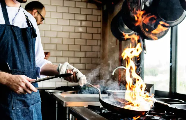 A Voleena chef cooking over a flaming wok